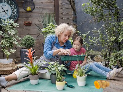 Herb gardening by mother and daughter at backyard garden