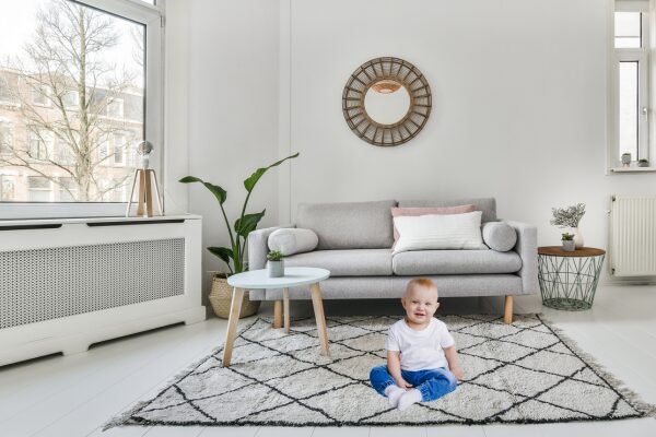 Baby sitting on a carpet in their living room